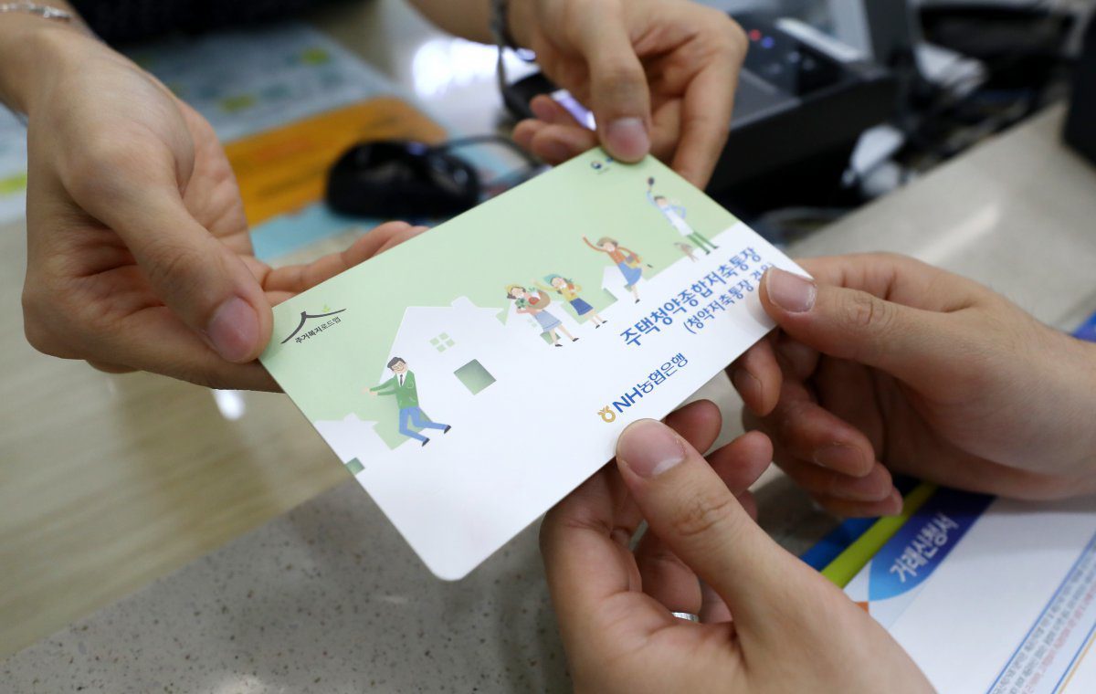 은행 창구에서 주택청약종합저축 통장을 건네받는 모습