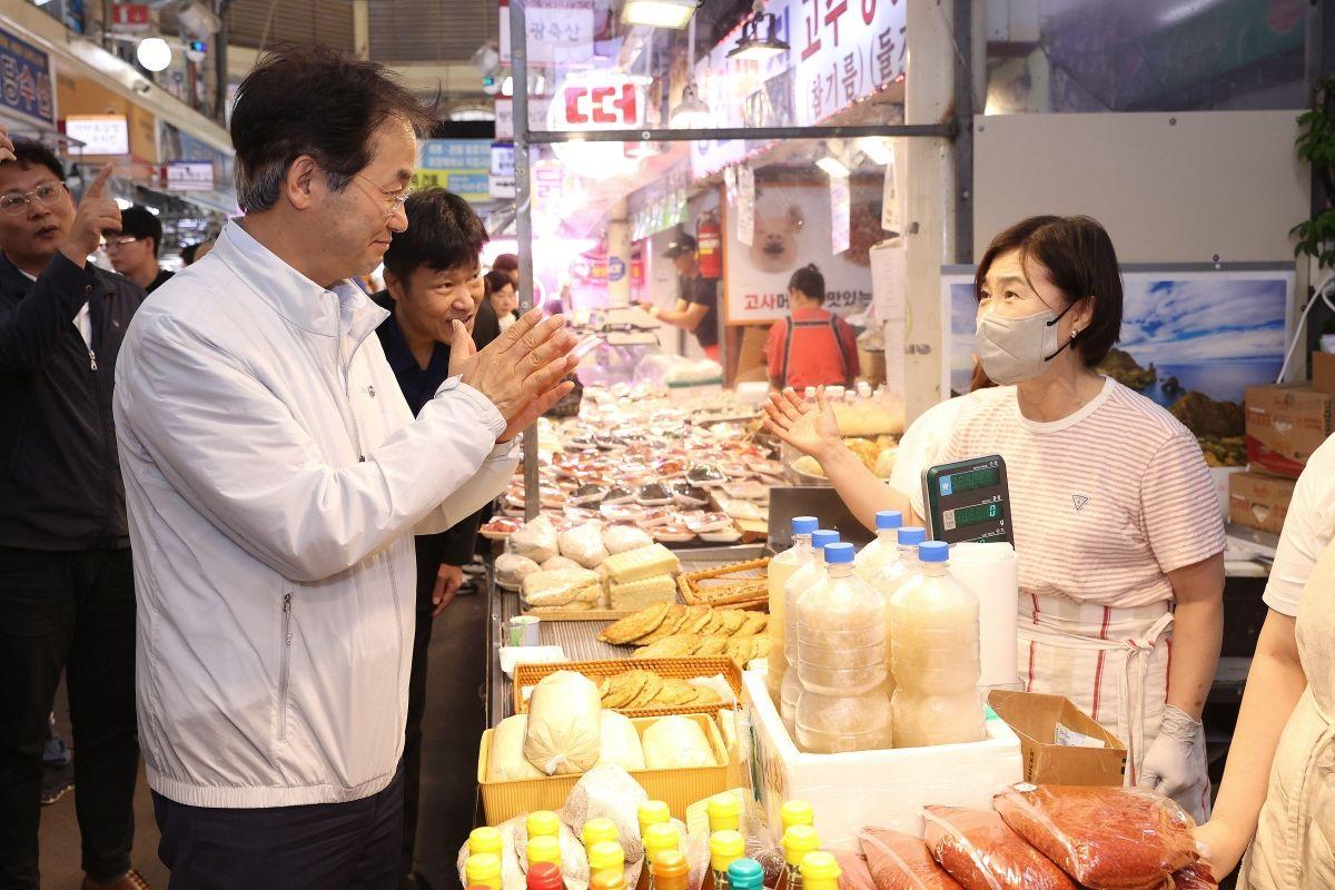 전통시장에서 상인과 방문객이 대화하는 모습
